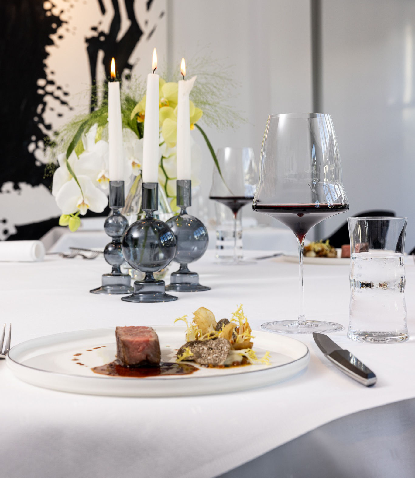 Die Tischkomposition mit Gericht, Gläsern und Besteck in der Bagatelle